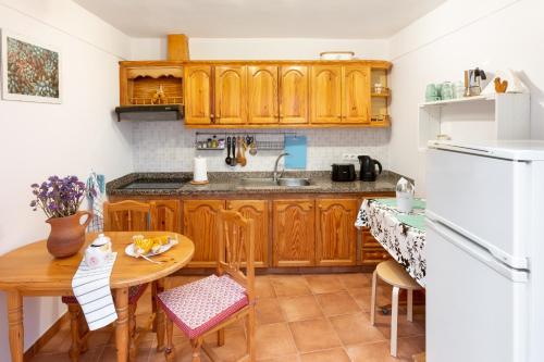 eine Küche mit Holzschränken und einem Holztisch in der Unterkunft Tabaiba Guesthouse in Buenavista del Norte