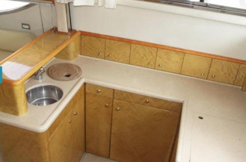 uma pequena cozinha com um lavatório e armários de madeira em Yacht -Central London St Kats Dock Tower Bridge em Londres
