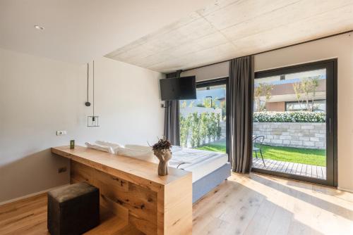 a room with a bed and a large window at OLEEVA Garda Living - Adults Only in Riva del Garda