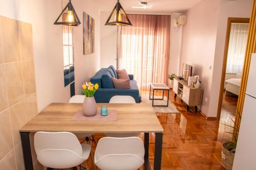 a living room with a table and a blue couch at Harizma apartmani in Kragujevac