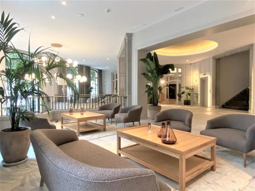 a lobby with couches and tables and potted plants at Lamaro Hotel in Barcelona