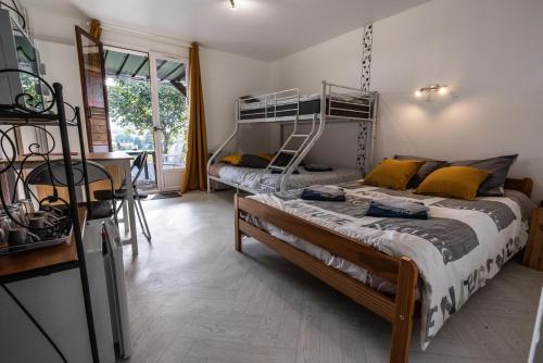 a bedroom with two bunk beds and a table at La Maison au Bord du Lac in Chemillé-sur-Indrois