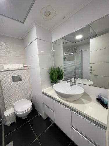 a white bathroom with a toilet and a sink at נופש כנרת מגדלי המלכים in Tiberias