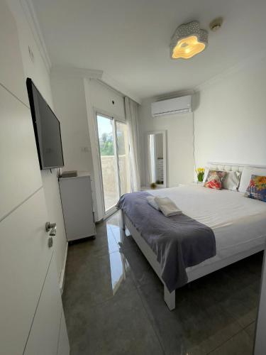 a bedroom with a bed and a flat screen tv at נופש כנרת מגדלי המלכים in Tiberias