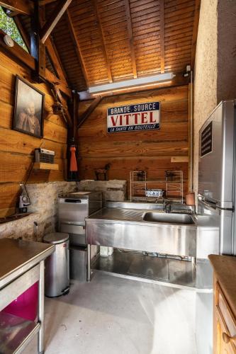 une cuisine avec un évier et un panneau mural dans l'établissement La Maison au Bord du Lac, à Chemillé-sur-Indrois