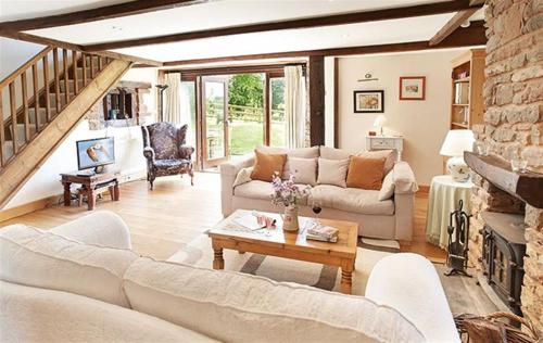 a living room with a couch and a table at Host & Stay - Tregaer Mill Barn in Dingestow