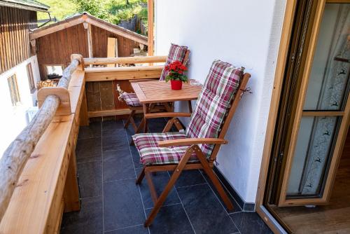 a porch with a table and chairs on a balcony at Haus Kogelleiten in Ramsau