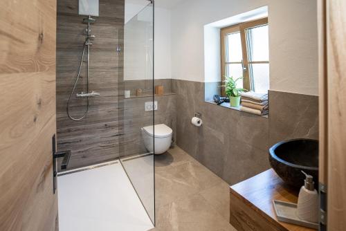 a bathroom with a glass shower with a toilet and a sink at Haus Kogelleiten in Ramsau