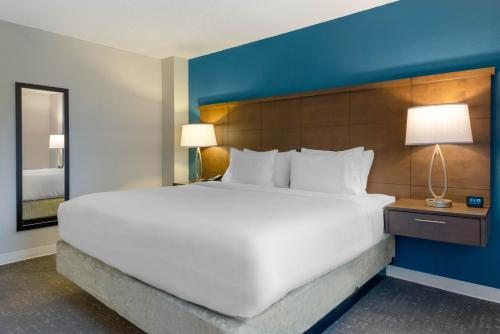 a hotel room with a large bed and a large mirror at Staybridge Suites - Orlando Royale Parc Suites, an IHG Hotel in Orlando