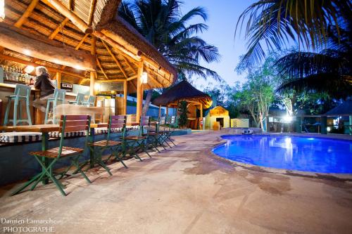 a man standing next to a resort with a swimming pool at Boa Gente Lodge in Vilanculos