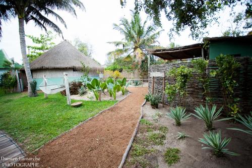 a garden with a bench and a house with a yard at Boa Gente Lodge in Vilanculos