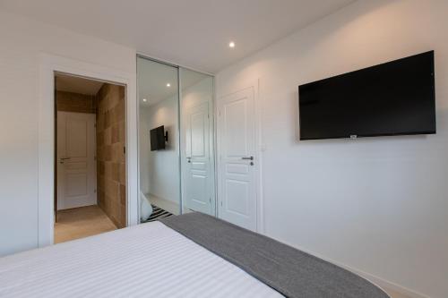 a bedroom with a bed with a flat screen tv on the wall at St Martin Nettlé Bay Lovely appartment in Baie Nettle