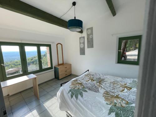 1 dormitorio con 1 cama y 2 ventanas en Villa Horizon - Piscine privée, en Montauroux