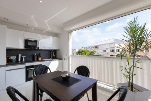 a kitchen with a table and chairs and a large window at St Martin Nettlé Bay Lovely appartment in Baie Nettle