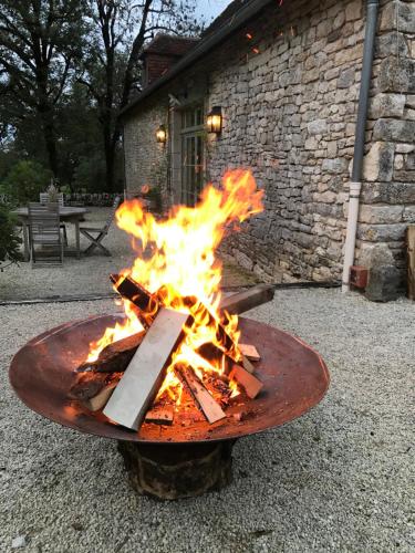 a fire pit in front of a brick building at Manoir de Malagorse in Cuzance