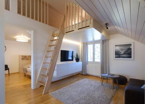 a room with a loft bed and a living room at Neuhof Gäste-& Schokohaus in Appenzell