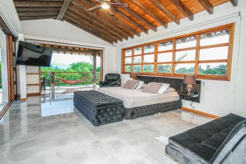 a bedroom with a bed and a couch and a television at San Miguel de Montenegro in Montenegro