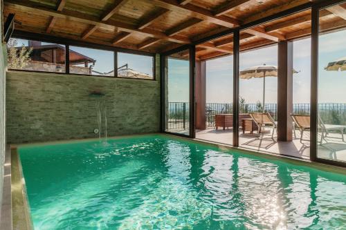 a swimming pool in a house with windows at Villa Di Sotto in Castelnuovo Berardenga