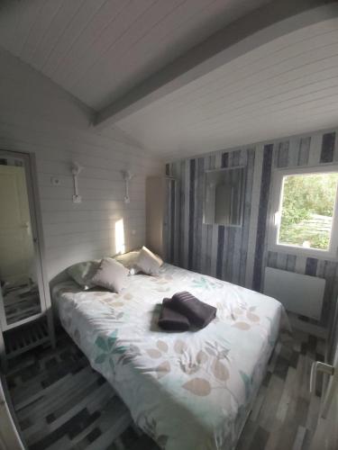 a bedroom with a bed with a robe on it at Chalet T3/clim/wifi/pkg/terrasse/15 min plages in La Teste-de-Buch