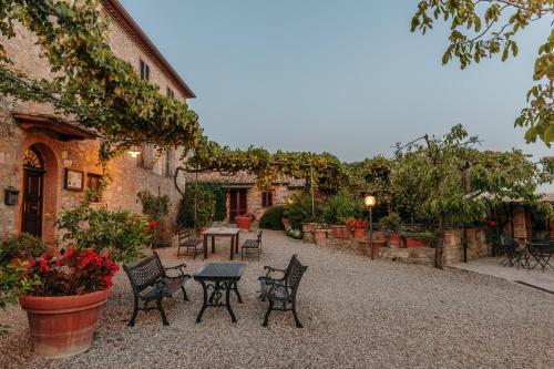 a courtyard with chairs and a table in a building at Villa Di Sotto in Castelnuovo Berardenga
