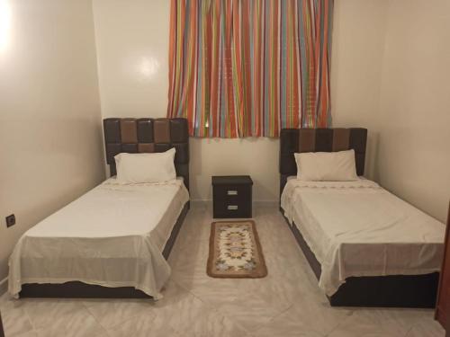 Zimmer mit 2 Betten und einem Fenster in der Unterkunft Résidence Assafae Harhoura in Temara