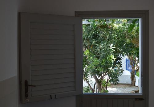 an open window with a view of a tree at Aegean Village in Parikia