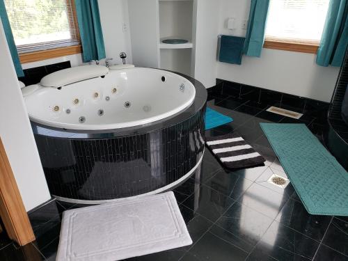 een badkamer met een jacuzzi in een kamer bij The Starlight Tower Hot Tub Suite with 8-Jet Massage Shower and Amazing Views in Fort Atkinson