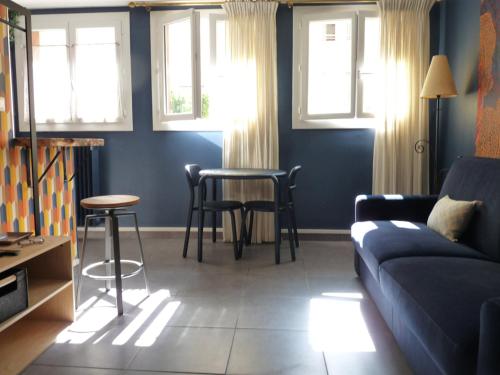 a living room with a couch and a table and windows at LE LOGIS DU PALAIS in Marseille