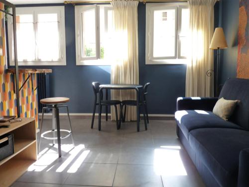 - un salon avec un canapé, une table et des fenêtres dans l'établissement LE LOGIS DU PALAIS, à Marseille