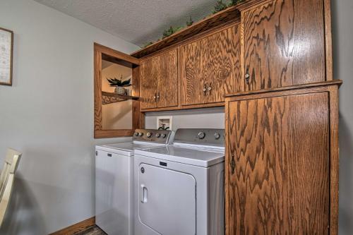 Una lavadora y secadora blancas en una cocina con armarios de madera. en Cozy Goshen Farmhouse about 9 Mi to Amish Acres, en Goshen