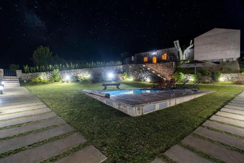 a backyard with a pool at night with lights at Casa do Castanheiro - Nordeste, Açores in Nordeste