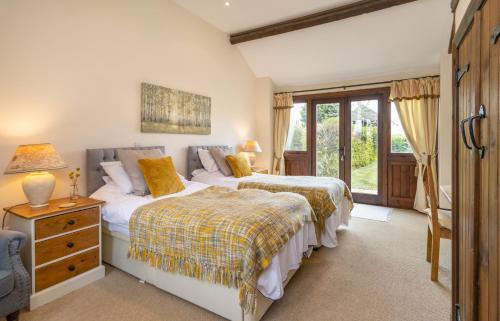 a bedroom with two beds and a window at The Old Stables in Yeovil