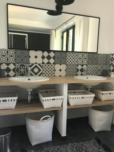 a bathroom with two sinks and a mirror at Domaine du Plessis in Le Plessis-Luzarches