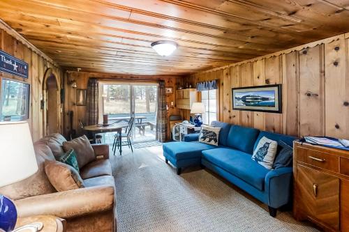 a living room with a blue couch and a table at Backcountry Bungalow in Joseph