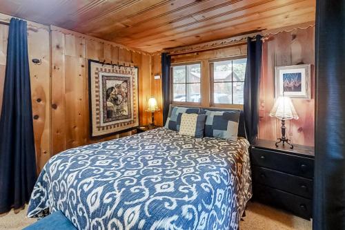 a bedroom with a bed in a room with wooden walls at Backcountry Bungalow in Joseph