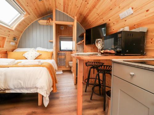 a bedroom with a bed and a kitchen in a cabin at Lapwing Lodge in Lancaster