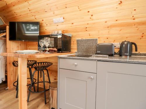 a kitchen with a counter with a microwave and a table at Lapwing Lodge in Lancaster