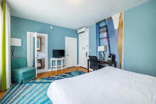 - une chambre avec un lit blanc et un mur bleu dans l'établissement The Exchange Hotel, à St Petersburg