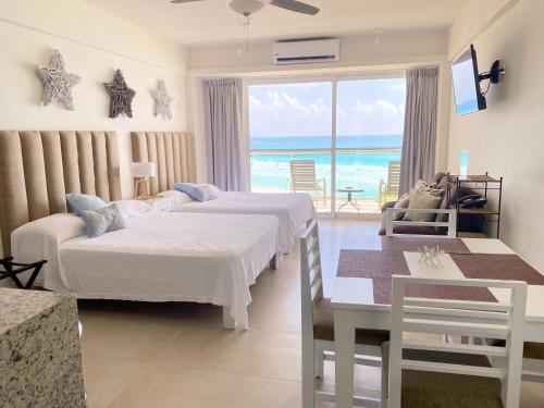 a hotel room with two beds and a view of the ocean at Salvia - Beachfront Studio in Cancún