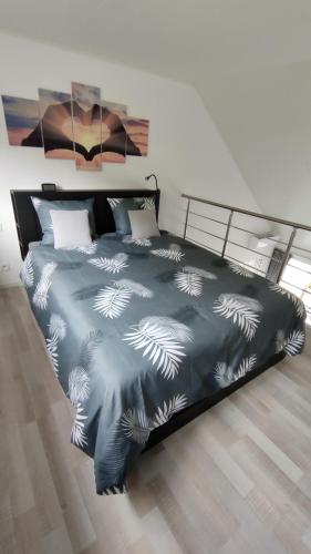 a bedroom with a bed with a blue comforter at LA TERRASSE 226 in Malmedy