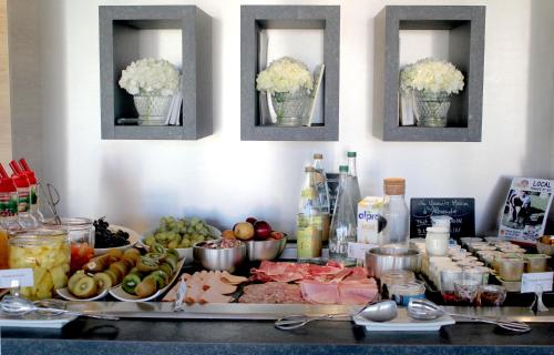 a counter with many different types of food on it at Hotel Litteraire Alexandre Vialatte, BW Signature Collection in Clermont-Ferrand