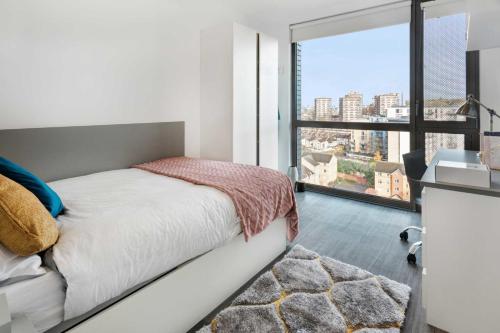 a bedroom with a bed and a large window at Chapter Lewisham in London in London