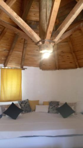 a bed in a room with a wooden ceiling at casa hobbit Puente Genil in Puente Genil