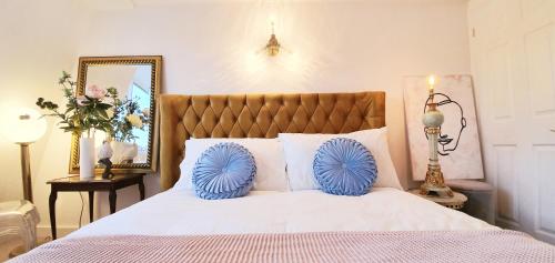 a bedroom with a bed with blue tufty pillows on it at Elegant 5 bed 4 bath 'Vogue House' Parisian style home in Margate