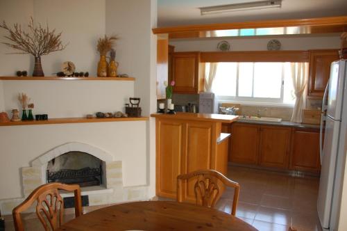 a kitchen with a table and a fireplace at Villa Chrysanthia in Polis Chrysochous