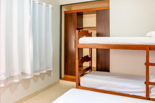a room with three bunk beds and a window at Recanto do Village in Porto Seguro