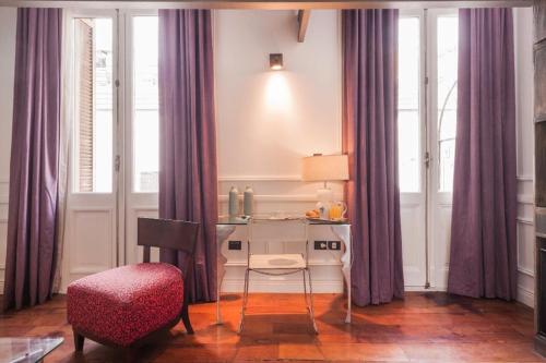 a room with a desk and a chair and windows at San Telmo Suites in Buenos Aires