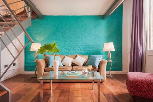 a living room with a couch and a green wall at San Telmo Suites in Buenos Aires