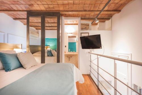 a bedroom with a bed and a flat screen tv at San Telmo Suites in Buenos Aires