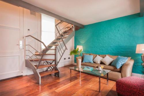 a living room with a couch and a staircase at San Telmo Suites in Buenos Aires
